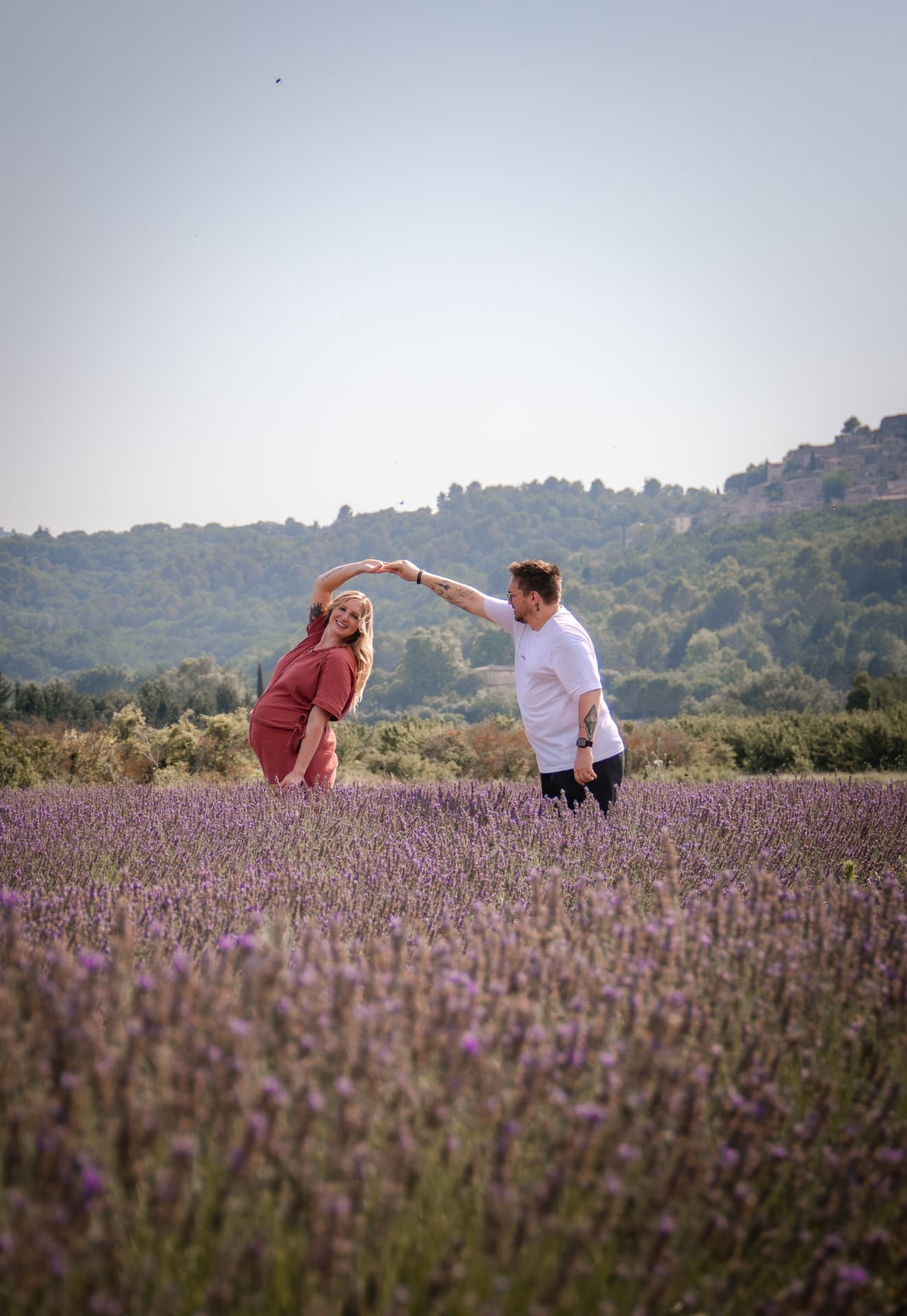 Couple dansant dans un champ de lavande devant un village perché
