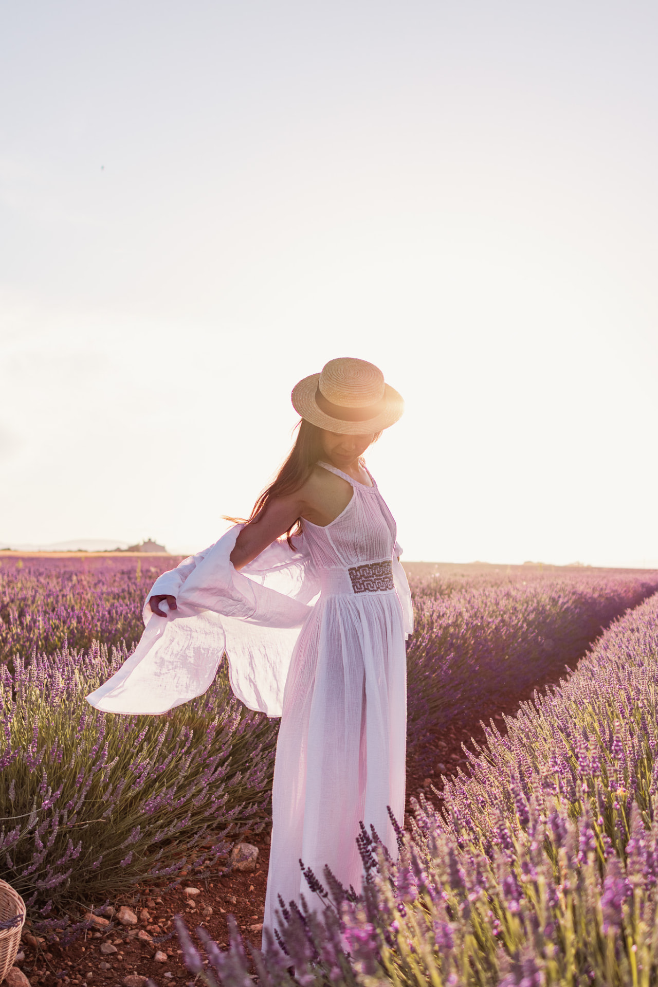 Femme en robe blanche dansant dans les rangs de lavande de Valensole