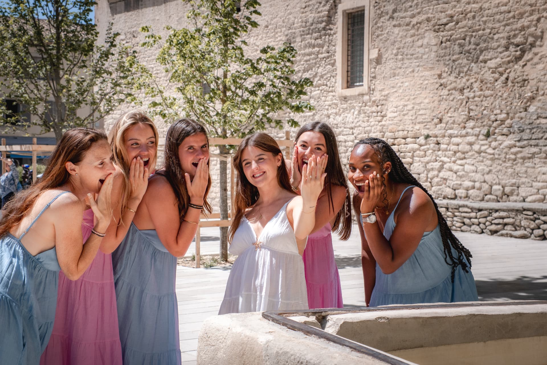EVJF — éclats de rire des amies autour d'une fontaine en Provence