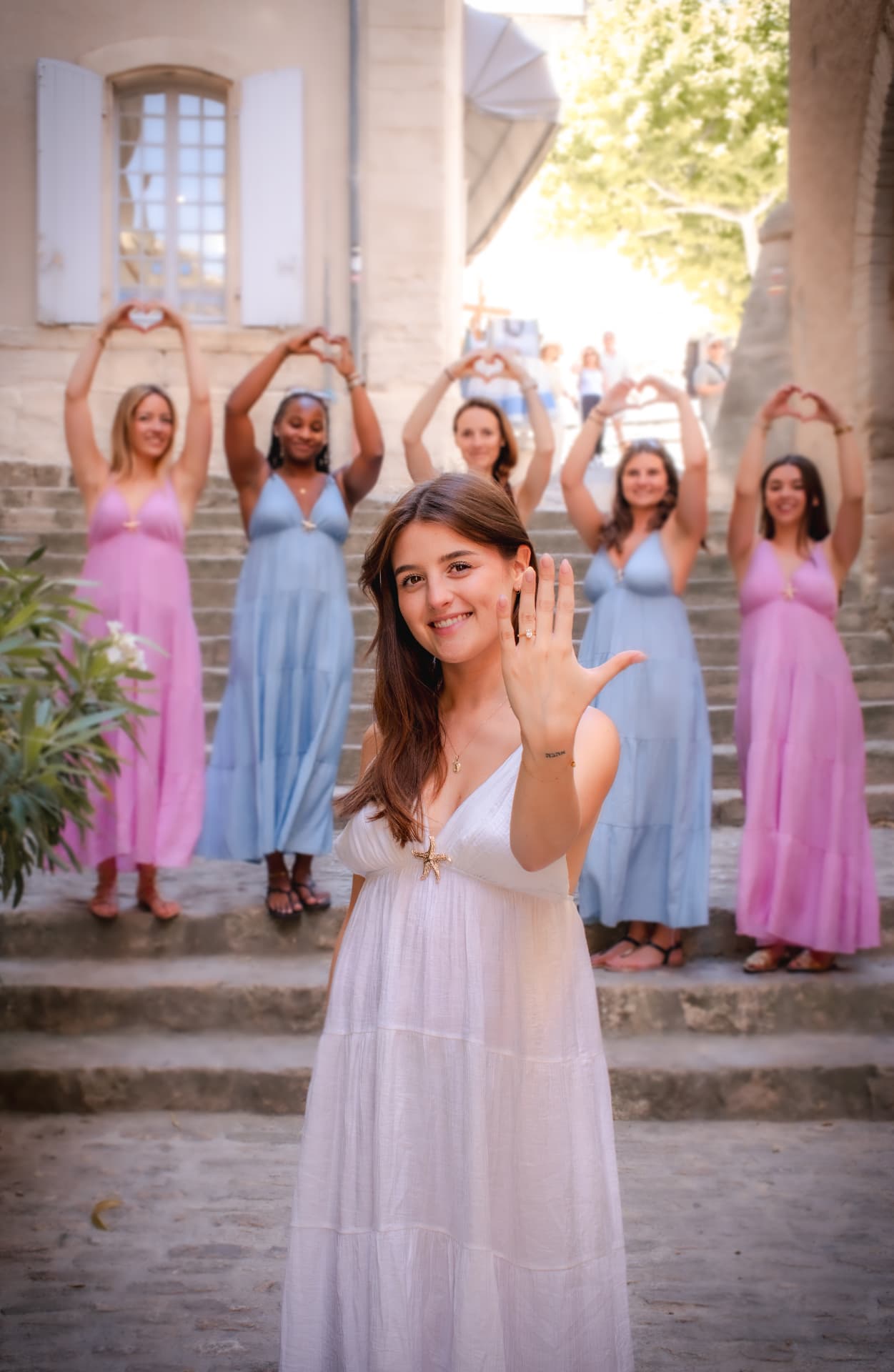 EVJF — la future mariée montrant sa bague de fiançailles entourée de ses amies