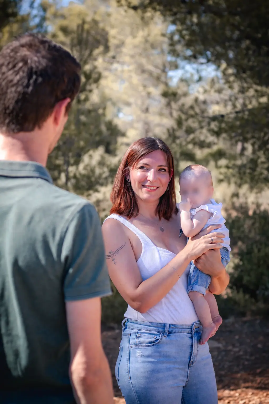 Maman portant son bébé et regardant le papa, séance naissance en Provence