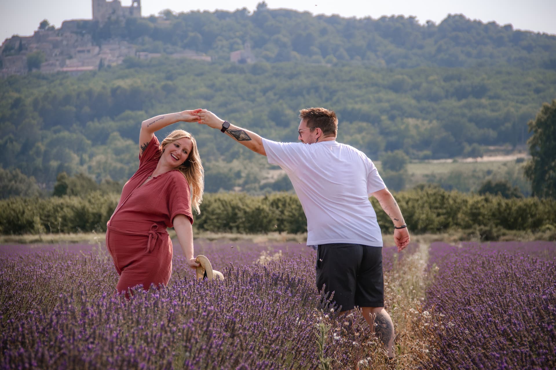 Couple dansant dans un champ de lavande devant un village perché de Provence