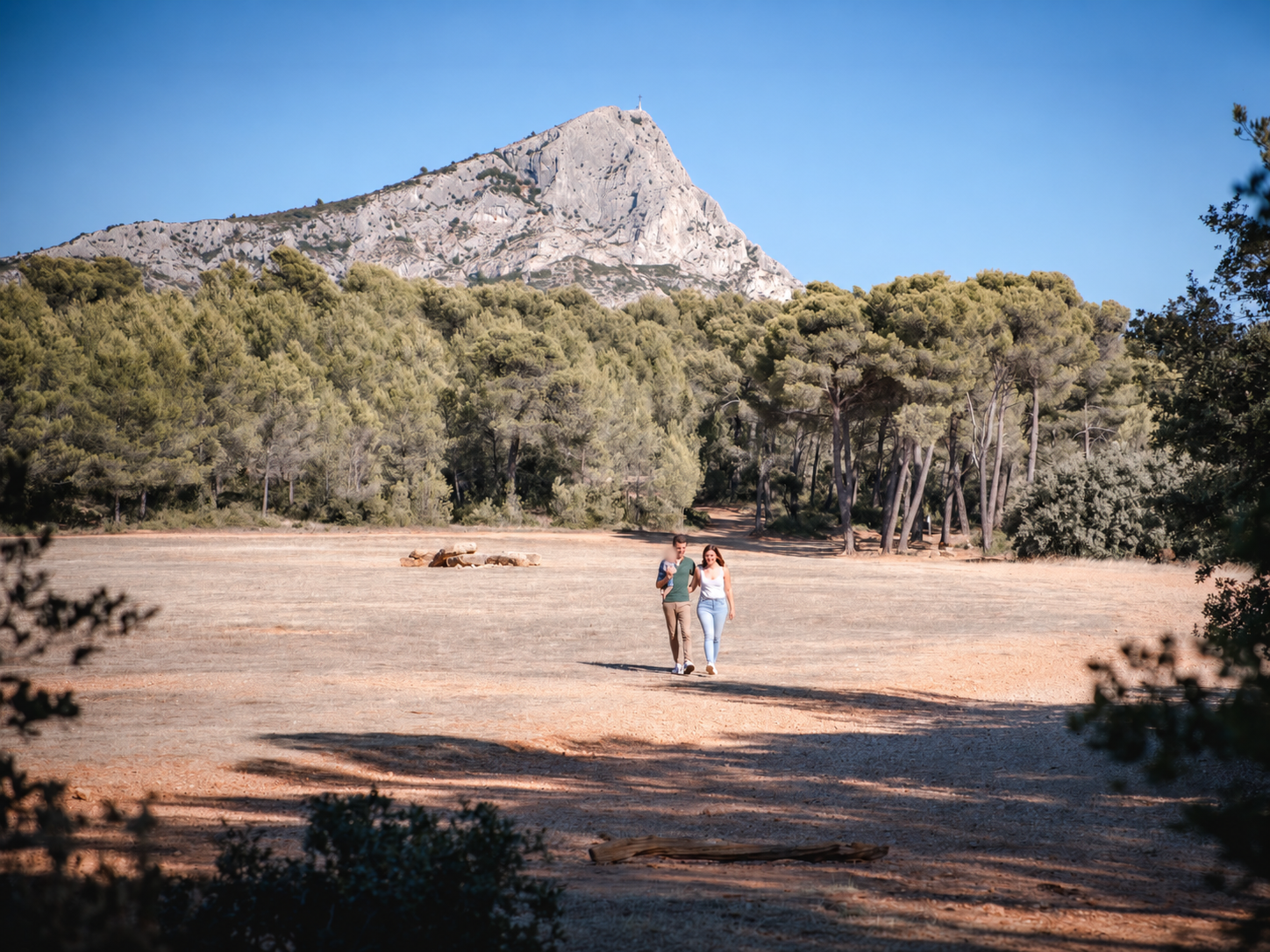 Jeunes parents marchant avec leur bébé devant la montagne Sainte-Victoire
