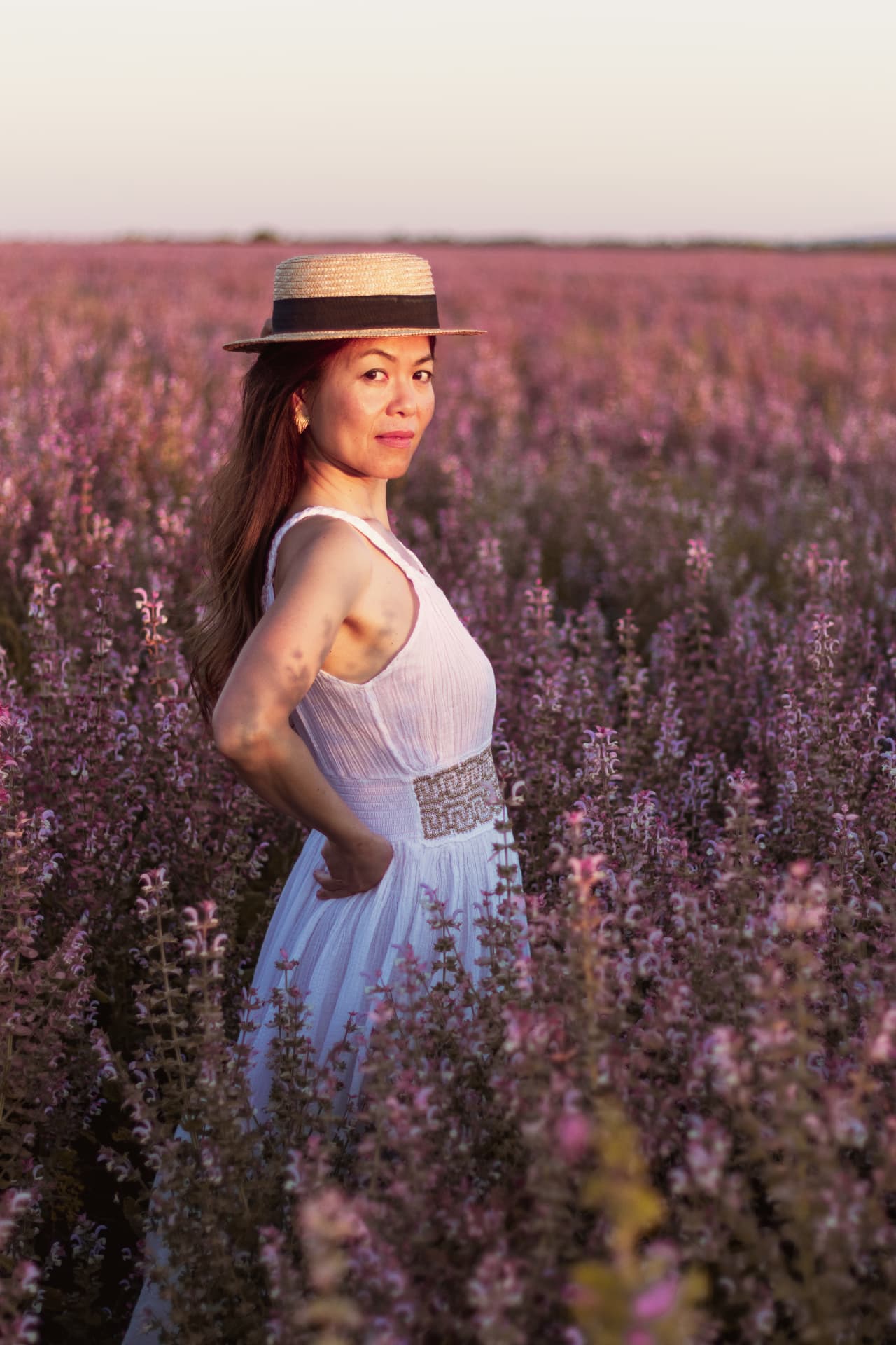 Portrait au chapeau de paille dans un champ de sauge sclarée en fleurs, Provence