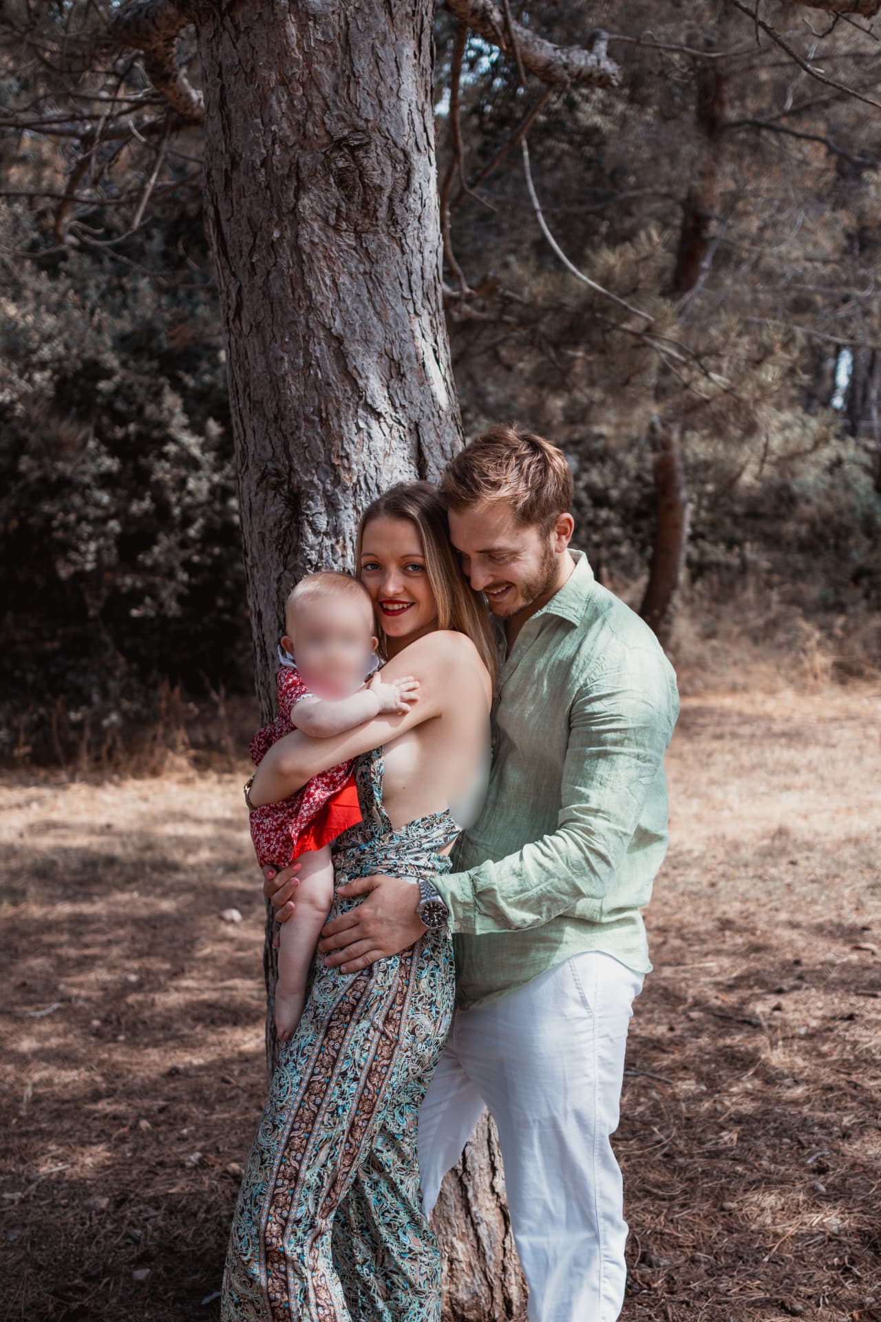 Parents enlacés avec leur bébé sous les pins, séance famille en Provence