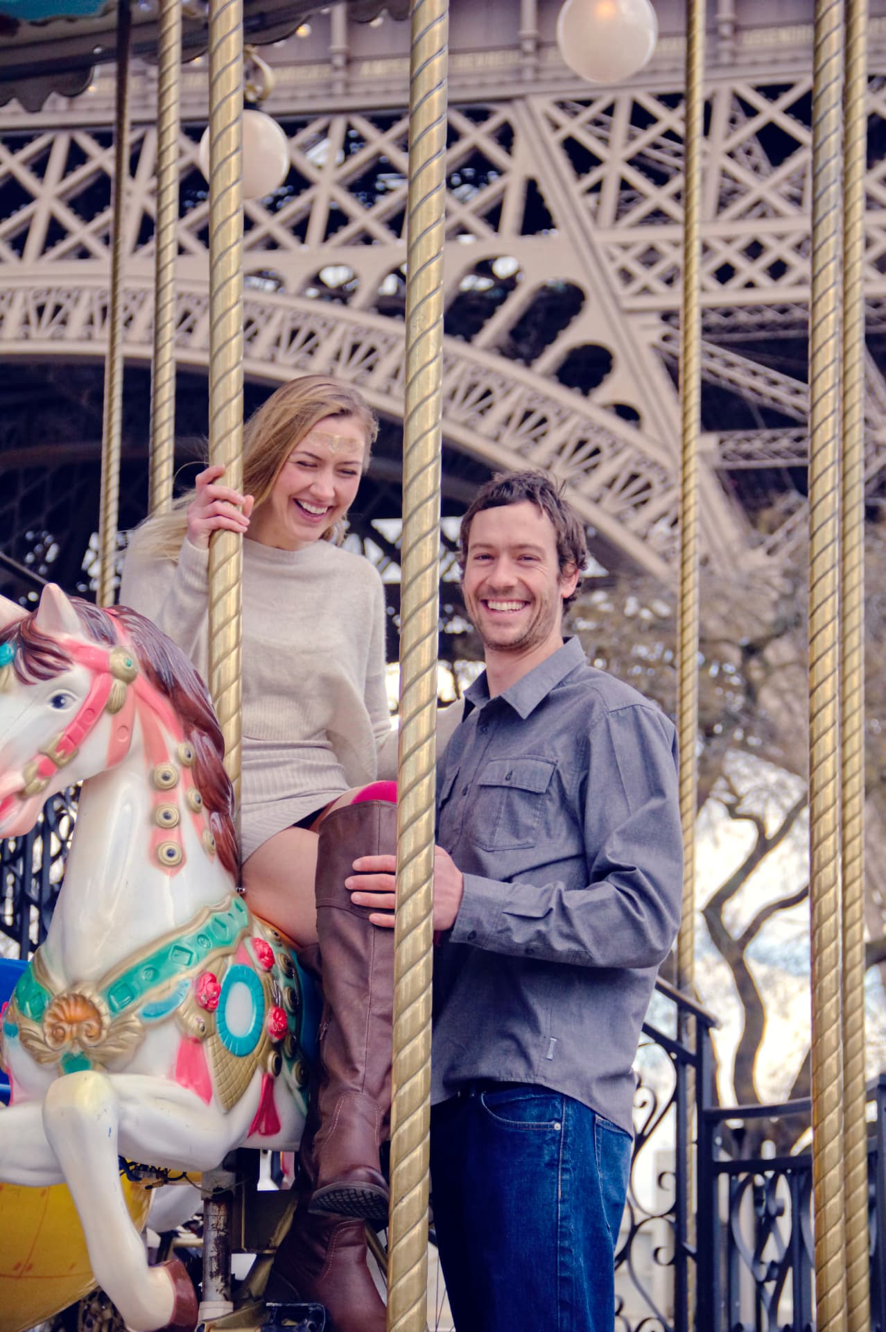 Couple riant sur le carrousel au pied de la Tour Eiffel à Paris