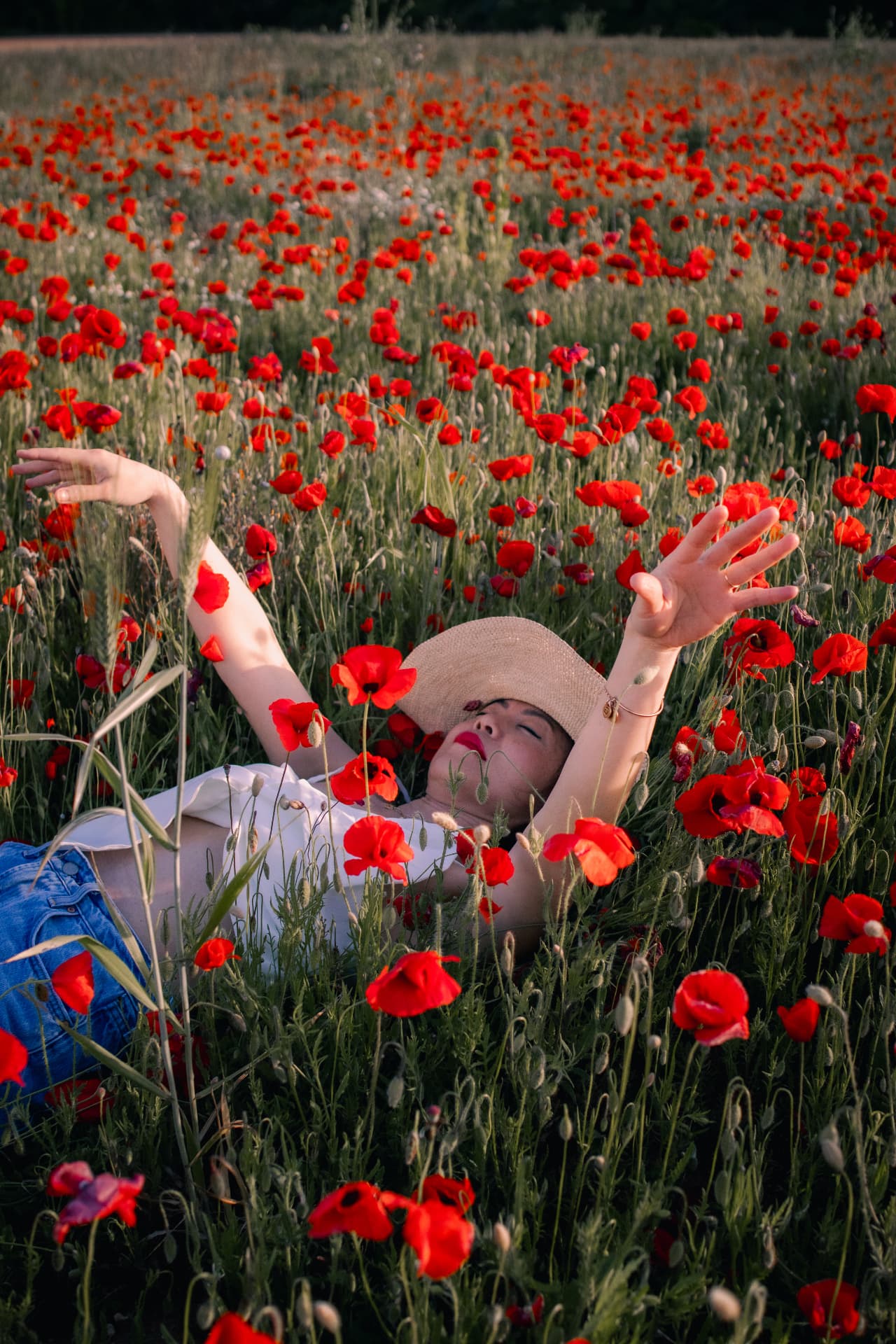Femme allongée dans un champ de coquelicots en Provence